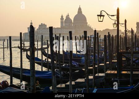 Gondola veneziana al tramonto, gondole ormeggiate a Venezia con la basilica di Santa Maria della Salute sullo sfondo, Italia