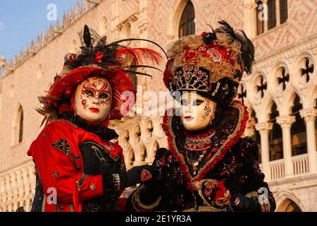 Due donne vestite con costumi e maschere decorati in stile tradizionale davanti al Palazzo Ducale durante il Carnevale di Venezia Foto Stock