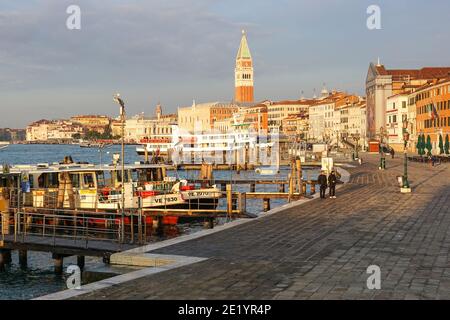 Lungomare di Venezia con il Campanile di San Marco e il Palazzo Ducale sullo sfondo, Italia Foto Stock