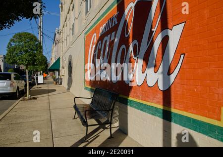 Un murale di Coca-Cola adorna il muro di un'azienda mentre il sole tramonta nel centro di Corinth, Mississippi. Corinth Coca-Cola Bottleworks fu fondata nel 1907. Foto Stock