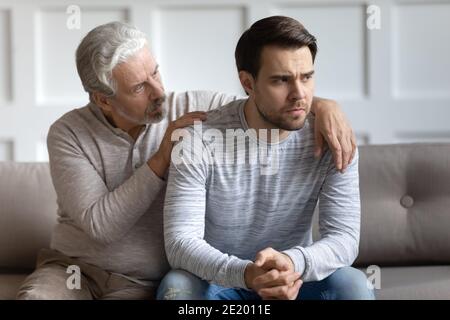 Cura del vecchio padre conforto sostenere il figlio adulto infelice Foto Stock