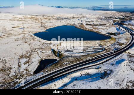 Vista aerea di una strada principale che attraversa un paesaggio innevato (A465, Galles, Regno Unito) Foto Stock