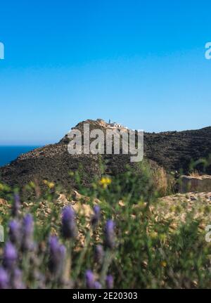 Vista sul faro imbiancato dietro fiori di lavanda sfocati nel parco naturale Serra Gelada ad Albir, Costa Blanca, Spagna Foto Stock