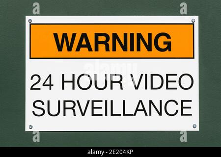 Avvertenza segnale di videosorveglianza 24 ore su sfondo verde metallico. Foto Stock