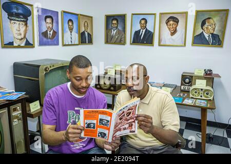 Alabama Mobile Africa Town Welcome Center mostra uomo, Black History padre adulto figlio in cerca di lettura, Foto Stock