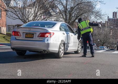 New York, Stati Uniti. 10 gennaio 2021. L'ufficiale della polizia di NYPD dirige il traffico al di fuori dell'hub vaccinale del Dipartimento della Salute di NYC alla Hillcrest High School in Giamaica. Le persone con più di 75 anni, gli operatori del settore dell'istruzione, la polizia e i vigili del fuoco, i lavoratori del trasporto pubblico e della sicurezza sono idonei a ricevere i vaccini come gruppo 1B. Il gruppo 1A comprende gli operatori sanitari. Più di 600 persone si sono registrate per essere vaccinate in questo luogo il primo giorno. Credit: SOPA Images Limited/Alamy Live News Foto Stock