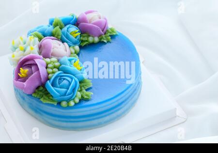 Torta minimale fatta da torta dolce di strato di panda e decorata fiori carini di wite su panno bianco. Dessert tailandese Foto Stock