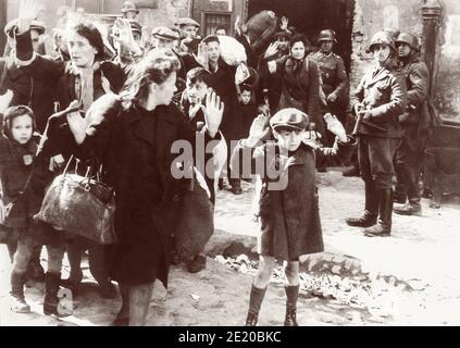 Un ragazzo alza le mani sulla testa mentre i soldati nazisti rimuovono forzatamente gli ebrei polacchi nel ghetto di Varsavia per essere trasportati in treno al campo di sterminio di Majdanek o Treblinka. Una delle fotografie più iconiche della seconda guerra mondiale, l'immagine, probabilmente da aprile o maggio 1943, è stata inclusa nel rapporto Stoop dato a Heinrich Himmler dalla SS e dal capo della polizia Jürgen Stroop. Foto Stock