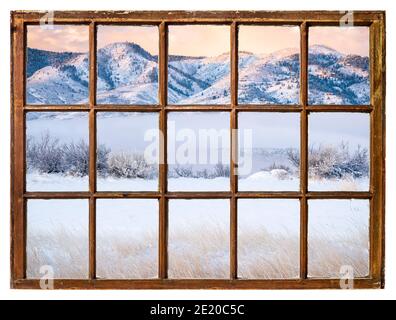 scenario di un lago di montagna e valle coperta di nebbia all'alba di inverno come visto da una finestra di cenere di cabina d'epoca Foto Stock