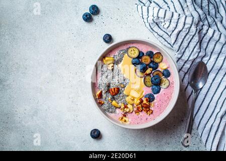 Ciotola Acai con semi di chia, bacche, noci e burro di arachidi. Concetto di colazione salutare. Foto Stock