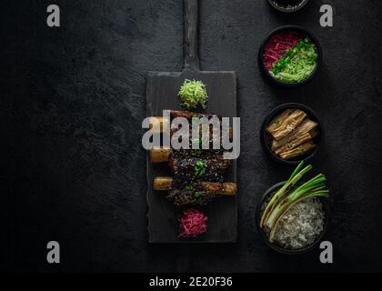 Costolette di manzo brasato, stile asiatico con riso e rafano, foto scura, spazio per la copia. Foto Stock