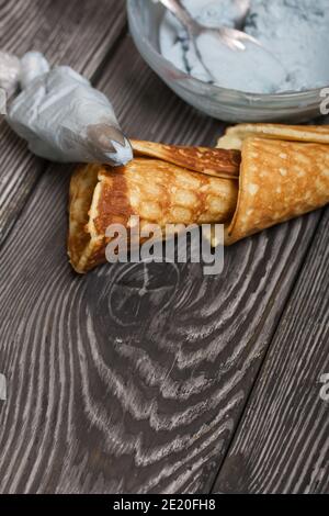 Ingredienti per la preparazione di dessert. Formaggio cremoso di diversi colori, coni di cialda e cioccolato. Foto Stock