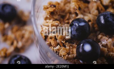 Mangiare sano. Colazione naturale con cereali, muesli, latte. Fondo bianco, cibo vegetariano biologico. Pasto leggero con dieta mattutina. Chiudi Foto Stock