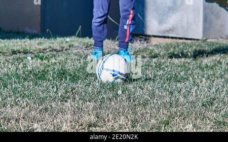 Ragazzo prima di calciare una palla di calcio. Foto Stock