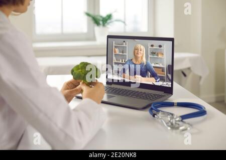 Video medico che chiama il cliente senior e che le dice dei benefici di dieta sana Foto Stock