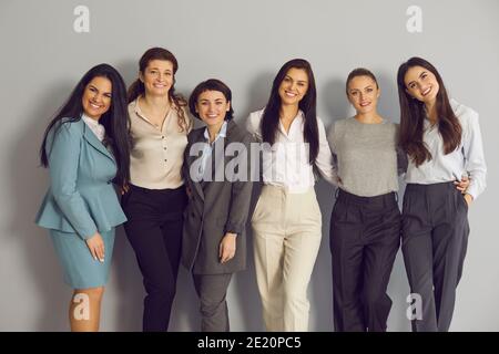 Team di professionisti aziendali di successo che si levano in piedi insieme e sorridono a. fotocamera Foto Stock