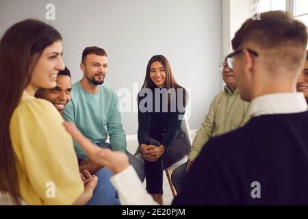 Le persone multirazziali si siedono in un cerchio e ascoltano la storia del partecipante all'incontro. Foto Stock