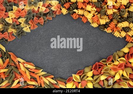 Italiano sano tricolore cibo pasta astratta sfondo confine su ardesia. Disposizione piatta, vista dall'alto. Foto Stock