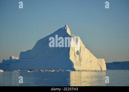 Enormi iceberg nella baia di Disko, Ilulissat icefjord al sole di mezzanotte nel mese di luglio, patrimonio mondiale dell'UNESCO influenzato dal cambiamento climatico Foto Stock