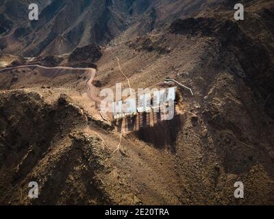 Segno di benvenuto della città di Hatta scritto con lettere grandi poste dentro Montagne Hajar nell'enclave Hatta di Dubai negli Stati Uniti Vista aerea degli Emirati Arabi Foto Stock