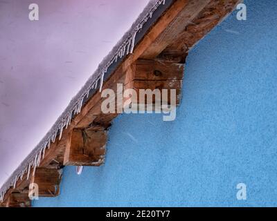 Iciclette sul bordo del tetto - fiocchi di neve sfocati in movimento Foto Stock