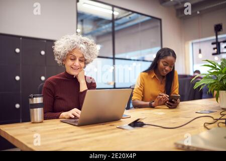 Due Businesswomen che lavorano nell'area Break out dell'ufficio moderno Foto Stock