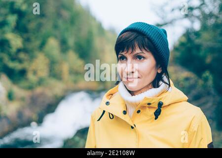 Uno con la natura. Vista posteriore di una donna irriconoscibile che guarda alla foresta e alla cascata Foto Stock