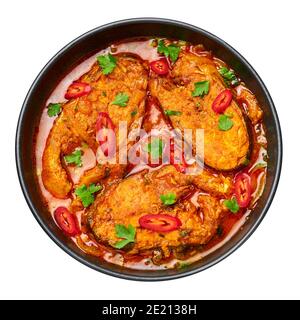 Macher Jhol in ciotola nera isolata su bianco. Cucina indiana Bengalese Pesce curry. Cibo e pasti asiatici. Vista dall'alto Foto Stock