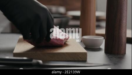 uomo mettere carne di manzo cruda su tavola di quercia, foto ampia Foto Stock