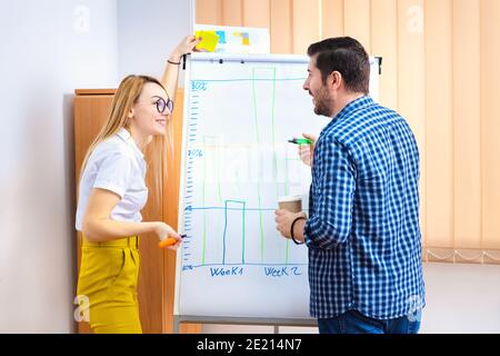 Due persone che discutono di vendite e strategia di marketing in ufficio Foto Stock