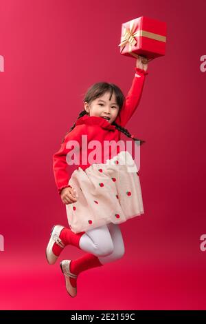 Ragazza piccola felice che tiene un regalo di festa Foto Stock