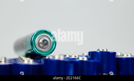 Molte batterie alcaline AA e AAA su sfondo bianco. Concetto di riciclaggio ecologico. I terminali delle batterie monouso sono vicini Foto Stock