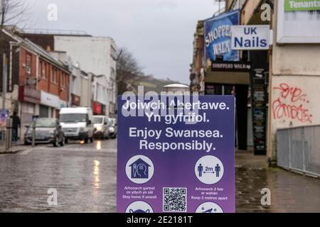 Swansea, Regno Unito. 11 Gennaio 2021. Segno di allontanamento sociale su Oxford Street nel tranquillo centro della città di Swansea questa mattina come blocco durante l'altezza della pandemia di Coronavirus continua in tutto il Regno Unito. Credit: Phil Rees/Alamy Live News Foto Stock