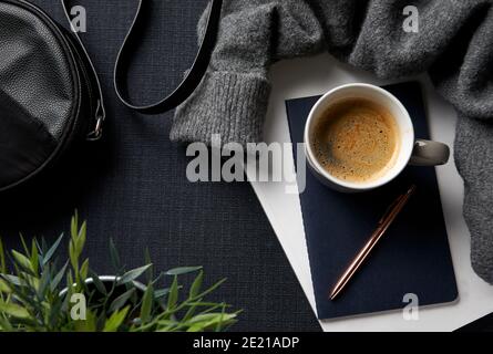 Flat Lay Lifestyle Shot con jumper notebook e borsa Sfondo nero Foto Stock