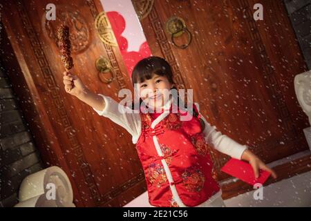 Felice bambina che tiene una confettura di bacche ricoperte di zucchero Foto Stock