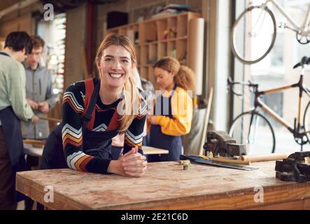 Donna piccola impresa Proprietario in officina assemblaggio mano costruito sostenibile Biciclette di bambù Foto Stock