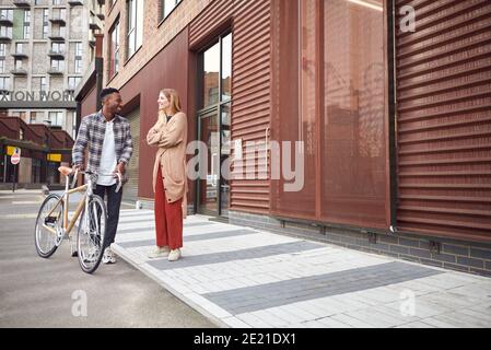 Giovane coppia a piedi in City Street con sostenibile Bamboo Bicycle Foto Stock