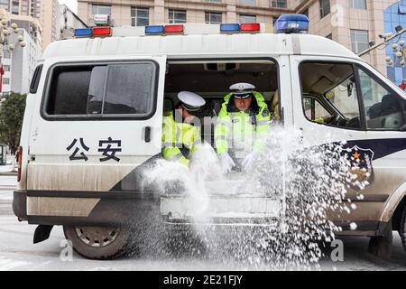 (210111) -- PANZHOU, 11 gennaio 2021 (Xinhua) -- i poliziotti del traffico diffondono sale industriale, un agente gelificante, sul ponte di Donghu a Panzhou City, nella provincia di Guizhou, nel sud-ovest della Cina, 11 gennaio 2021. La recente forte ondata di freddo ha portato alla congelazione a Panzhou e in molti altri luoghi a Guizhou. Circa 400 poliziotti del traffico a Panzhou stanno lavorando 24 ore su 24 per rimuovere le superfici stradali di rivestimento del ghiaccio della città. Il verde fluorescente sulle loro giacche sembra essere il colore più caldo in un inverno gelido. (Xinhua/ou Dongqu) Foto Stock