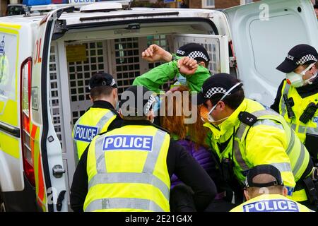 Edimburgo, Scozia, Regno Unito. 11 gennaio 2021. Il manifestante è stato arrestato oggi in scene violente durante la manifestazione anti-blocco al Parlamento scozzese di Edimburgo. Hanno preso parte diversi manifestanti, ma una presenza pesante e aggressiva della polizia ha impedito la dimostrazione e ha programmato la marcia a Bute House. Durante il blocco nazionale del Covid-19 tali proteste sono illegali e la polizia ha consigliato alle persone di non partecipare alla manifestazione. Iain Masterton/Alamy Live News Foto Stock