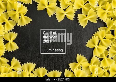 Cornice di un mucchio di pasta farfalle su sfondo nero scuro con copyspace. Colore dell'anno 2021 Foto Stock