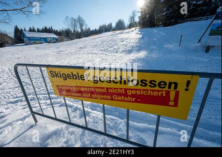 Bischofsmais, Germania. 11 Gennaio 2021. 'Area sci chiusa' è scritto su un cartello di fronte ad una pista da sci a Geisskopf, nel distretto di Regen. Numerose contee e città indipendenti in Baviera vogliono chiudere i loro confini a escursionisti di giorno. Credit: Armin Weigel/dpa/Alamy Live News Foto Stock