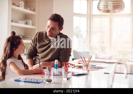 Figlia a casa con Padre che ha divertimento che fa l'artigianato insieme Foto Stock