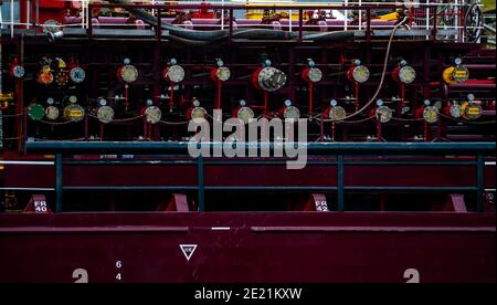 Collettori e tubi su una grande nave cisterna mercantile ormeggiata al porto. Foto Stock