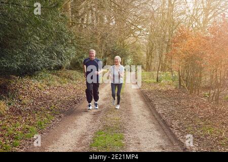 Coppia senior che si esercita nella campagna autunnale durante il Covid 19 Lockdown Foto Stock