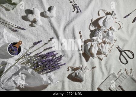 Sacchetti di lavanda fatti a mano in sacchetti di tessuto, cuori morbidi. Sacchetto per la presa a mano. Fiori secchi di lavanda per ripieno. Tovaglia in tessuto a posa piatta. Zero sprechi Foto Stock