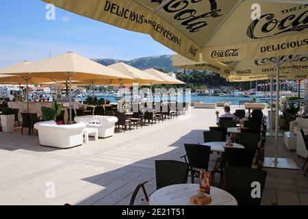 Ombrelloni ombreggiando i tavoli e le sedie di lato il caffè nella città vecchia di Rab, Rab isola Croazia Foto Stock