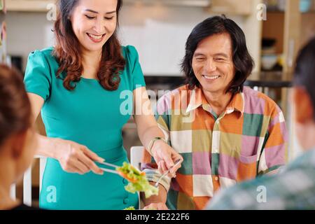 Casalinga che serve cibo a cena Foto Stock