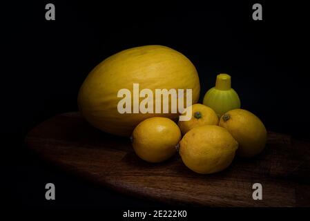 Frutta gialla reale e artificiale su tavola di legno Foto Stock