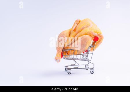 Pollo fresco crudo in un basket.A pollo intero in un carrello supermercato su sfondo bianco . Supermercato, cibo dietetico, pollo di carne bianca, reng gratuito. Foto Stock