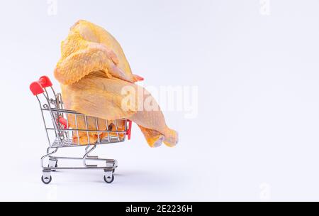 Pollo fresco crudo in un basket.A pollo intero in un carrello supermercato su sfondo bianco . Supermercato, cibo dietetico, pollo di carne bianca, reng gratuito. Foto Stock